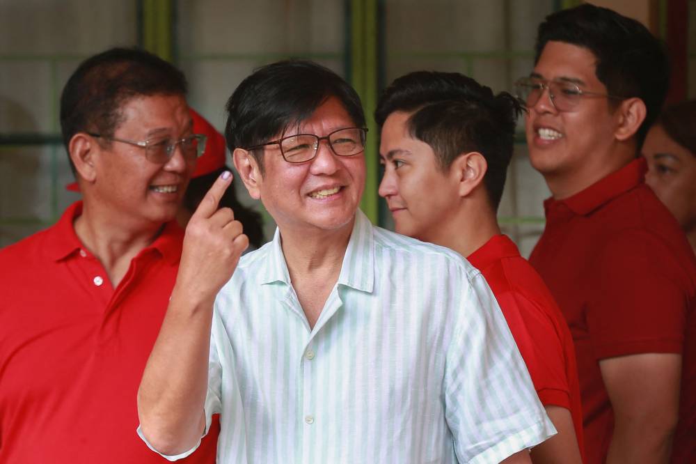 Philippine President Ferdinand Marcos shows his inked finger after voting in the mid-term election at a polling station in Batac town, Ilocos Norte province on May 12, 2025. - (Photo by AFP)