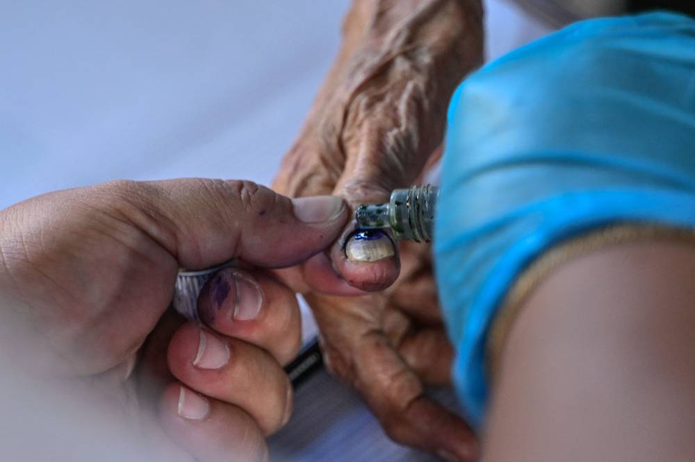 A voter's finger is marked with indelible ink at a polling station during the midterm elections in Manila on May 12, 2025. Millions of Filipinos headed to the polls May 12 in a mid-term election widely seen as a referendum on the explosive feud between President Ferdinand Marcos and impeached Vice President Sara Duterte. (Photo by Jam STA ROSA / AFP)