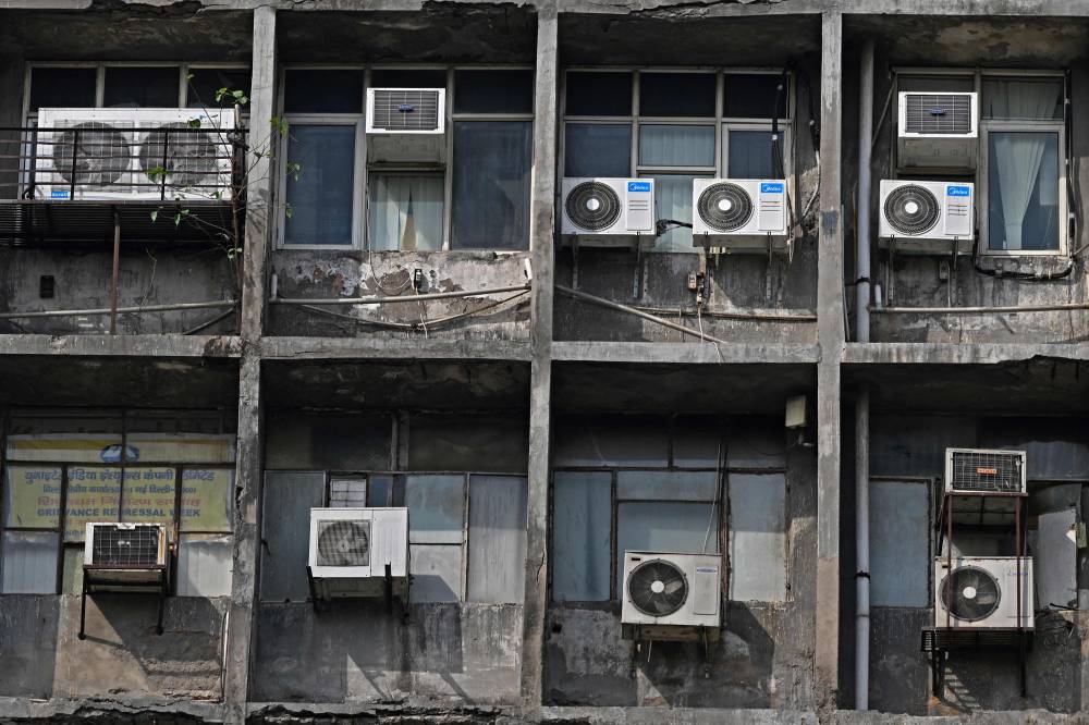 This picture taken on April 18, 2025 shows a general view of air conditioning units installed on the facade of a building in New Delhi. (Photo by Sajjad HUSSAIN/AFP)