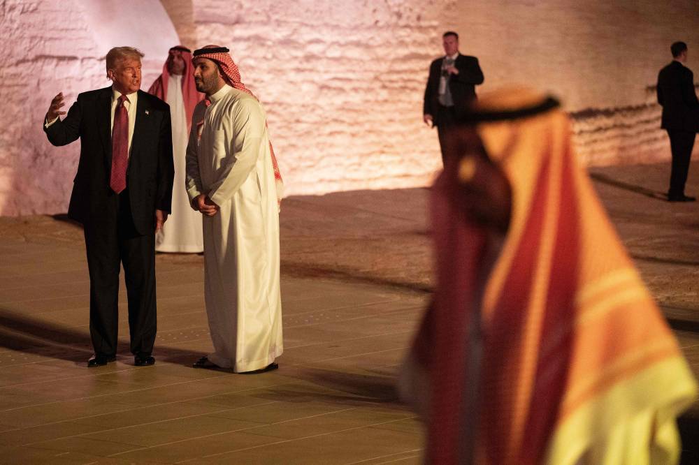 US President Donald Trump and Saudi Crown Prince Mohammed bin Salman walk in the old district of Diriyah on the outskirts of the Saudi capital Riyadh, before a state dinner on May 13, 2025. (Photo by Brendan Smialowski / AFP)