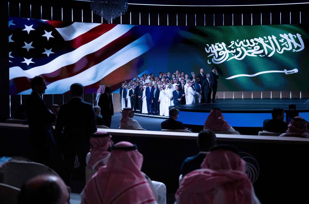 People wait to hear Saudi Arabia's Crown Prince Mohammed Bin Salman and US President Donald Trump speak during a Saudi-US investment forum at the King Abdul Aziz International Conference Center on May 13, 2025, in Riyadh, Saudi Arabia. (Photo by Brendan Smialowski / AFP)