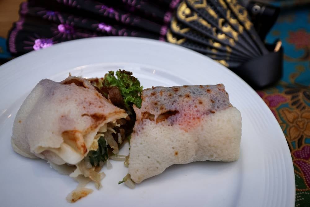 Nyonya popiah's filling is made from fresh ingredients such as jicama (sengkuang), cucumber, bean sprouts, omelette, fried tofu, and prawns, combined with sautéed fermented soybean paste (taucu) and garlic, resulting in a complex blend of sweet, spicy, and aromatic flavours. Photo by Bernama