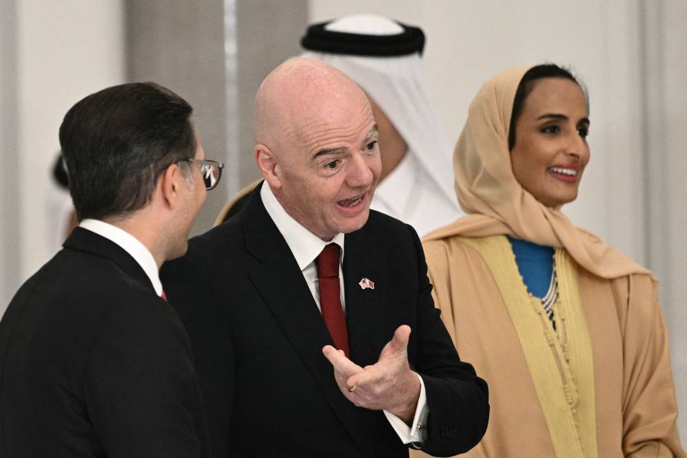 FIFA President Gianni Infantino (C) waits in line to greet Qatar's Emir and US President ahead of a state dinner at the Lusail Palace in Doha on May 14, 2025. (Photo by Brendan SMIALOWSKI / AFP)