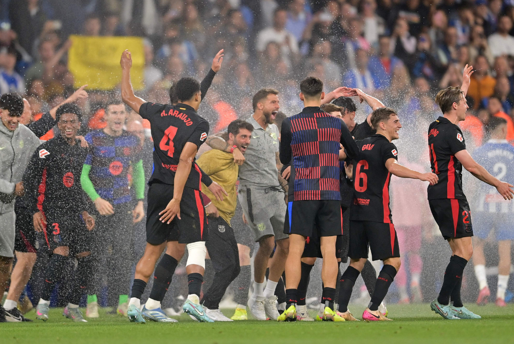 Barcelona players celebrate after winning their Spanish league football match between RCD Espanyol and FC Barcelona at the RCDE Stadium in Cornella de Llobregat, on May 15, 2025. (Photo by MANAURE QUINTERO / AFP)