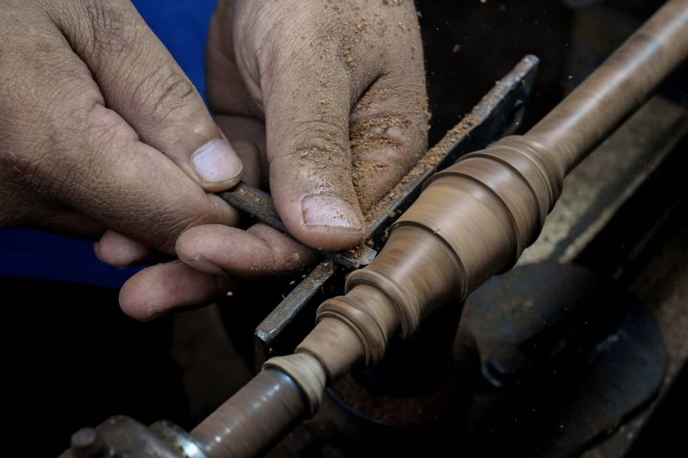 Serunai maker Mohd Izani Mohd Noor, 41, shapes wood to form the desired structure of the serunai at his workshop in Kampung Pulau Hilir, Kubang Kerian. Photo by Bernama