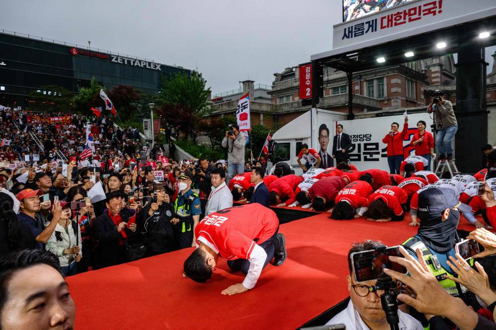 South Korean presidential candidate, Kim Moon Soo (C) of the People Power Party bows during a campaign event for the forthcoming June 3 presidential election in Seoul on May 19, 2025. (Photo by ANTHONY WALLACE / AFP)