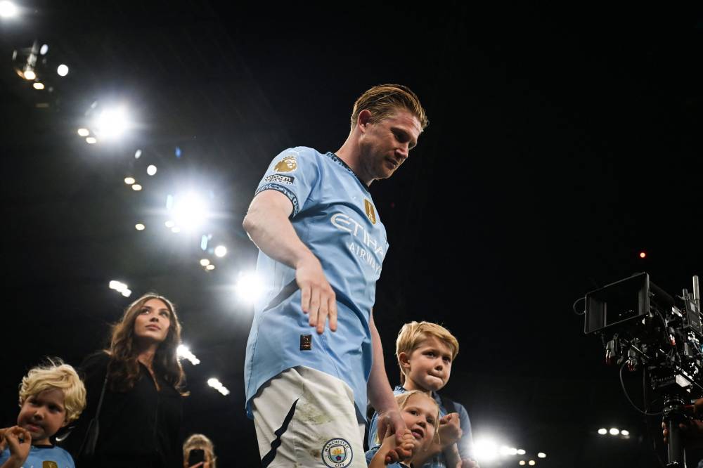 Manchester City's Belgian midfielder Kevin De Bruyne accompanied by his family does a tour of honour of the pitch after playing his last match with Manchester City at the Etihad Stadium at the end the English Premier League football match between Manchester City and Bournemouth at the Etihad Stadium in Manchester, north west England, on May 20, 2025. Manchester City wins 3 - 1 against Bournemouth. (Photo by Paul ELLIS/AFP)