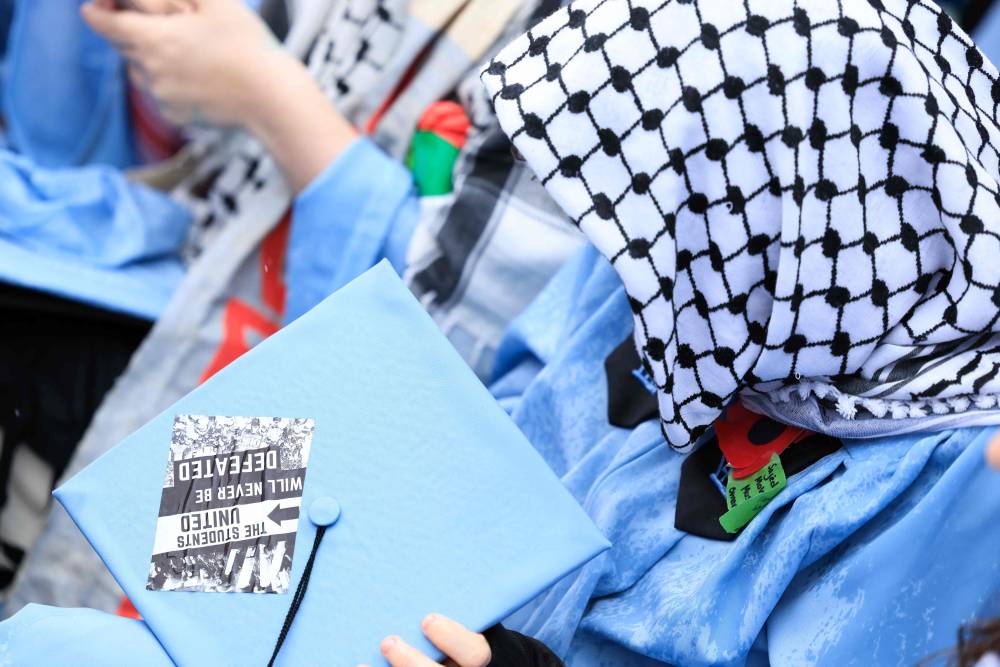 A Pro-palestinian student is seen during the Commencement Ceremony at Columbia University in New York on May 21, 2025. (Photo by CHARLY TRIBALLEAU/POOL/AFP)