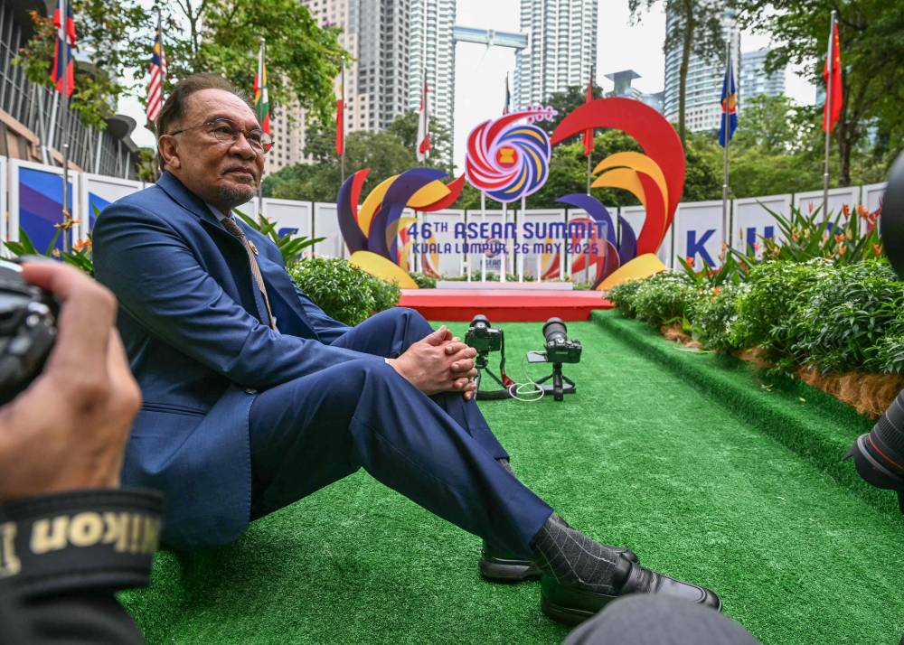 Prime Minister Datuk Seri Anwar Ibrahim speaks with the press as he waits to greet leaders before the plenary session at the 46th Association of Southeast Asian Nations (ASEAN) Summit in Kuala Lumpur on May 26, 2025. (Photo by MOHD RASFAN / POOL / AFP)