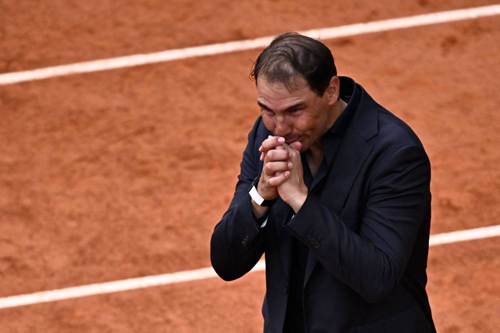 Former Spanish player Rafael Nadal reacts during a ceremony honoring his career on Court Philippe-Chatrier as part of the French Open tennis tournament at the Roland-Garros Complex in Paris on May 25, 2025. May 23, 2025, marked 20 years since Spain's Raphael Nadal shook Roland Garros with his first match at the French Open, changing the tennis tournament's history forever. Two decades and 14 titles later, the clay court legend, who retired in November 2024, will receive a tribute during the tournament on May 25, 2025. (Photo by JULIEN DE ROSA / AFP)