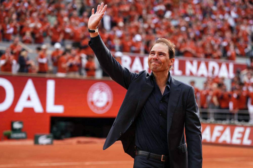 Former Spanish player Rafael Nadal waves to the crowd during a ceremony honouring his career during the French Open tennis tournament on Court Philippe-Chatrier at the Roland-Garros Complex in Paris on May 25, 2025. May 23, 2025, marked 20 years since Spain's Raphael Nadal shook Roland Garros with his first match at the French Open, changing the tennis tournament's history forever. Two decades and 14 titles later, the clay court legend, who retired in November 2024, will receive a tribute during the tournament on May 25, 2025. (Photo by Dimitar DILKOFF / AFP)