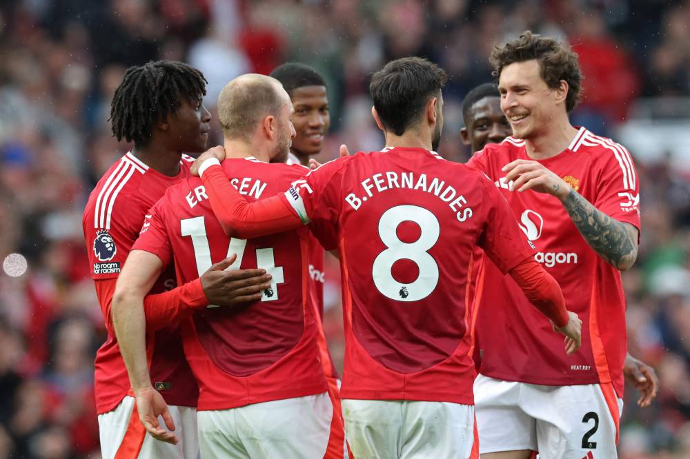 Manchester United's Danish midfielder #14 Christian Eriksen (2L) celebrates with teammates after scoring their second goal from the penalty spot during the English Premier League football match between Manchester United and Aston Villa at Old Trafford in Manchester, north west England, on May 25, 2025. (Photo by Darren Staples/AFP)