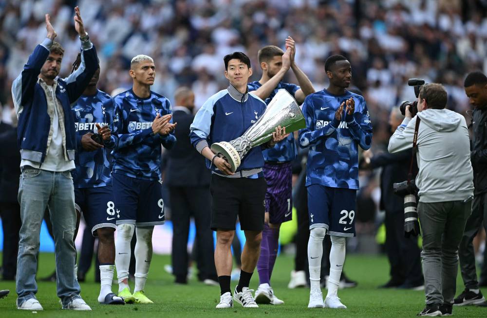 Tottenham Hotspur's South Korean forward Son Heung-Min carries the Europa League trophy, following their mid-week win in the Europa League Final on May 21, as he and the team display it for fans following the English Premier League football match between Tottenham Hotspur and Brighton and Hove Albion at the Tottenham Hotspur Stadium in London, on May 25, 2025. (Photo by JUSTIN TALLIS/AFP) 