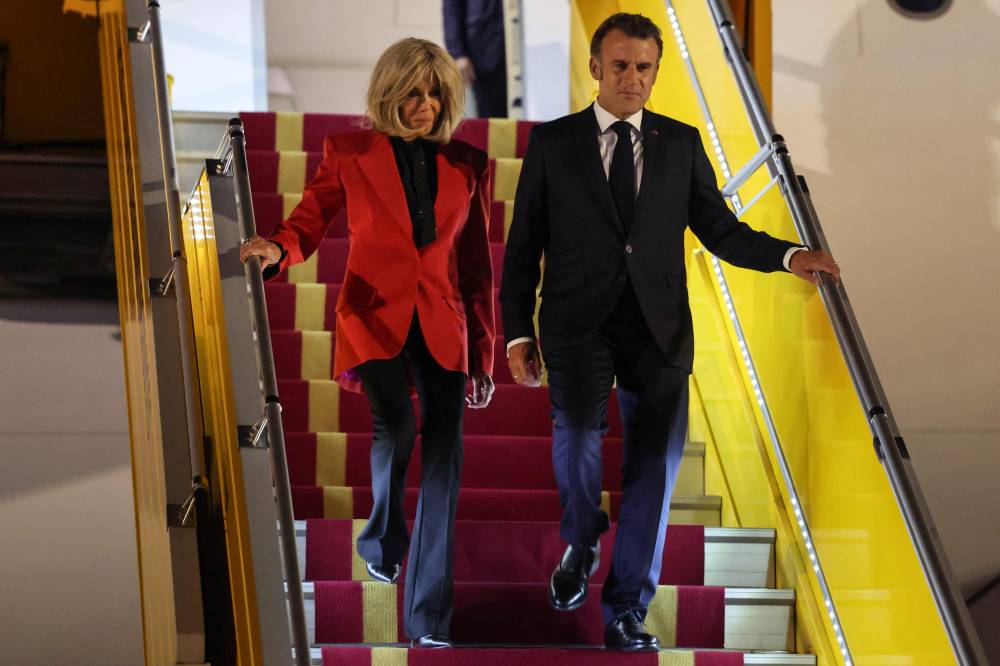 France's President Emmanuel Macron and his wife Brigitte Macron disembark from the plane upon their arrival at Noi Bai International Airport in Hanoi on May 25, 2025. French President Emmanuel Macron arrived in Hanoi on May 25, an AFP journalist saw, for the first leg of a Southeast Asia tour that will also see him travel to Indonesia and Singapore. (Photo by Ludovic MARIN/AFP)