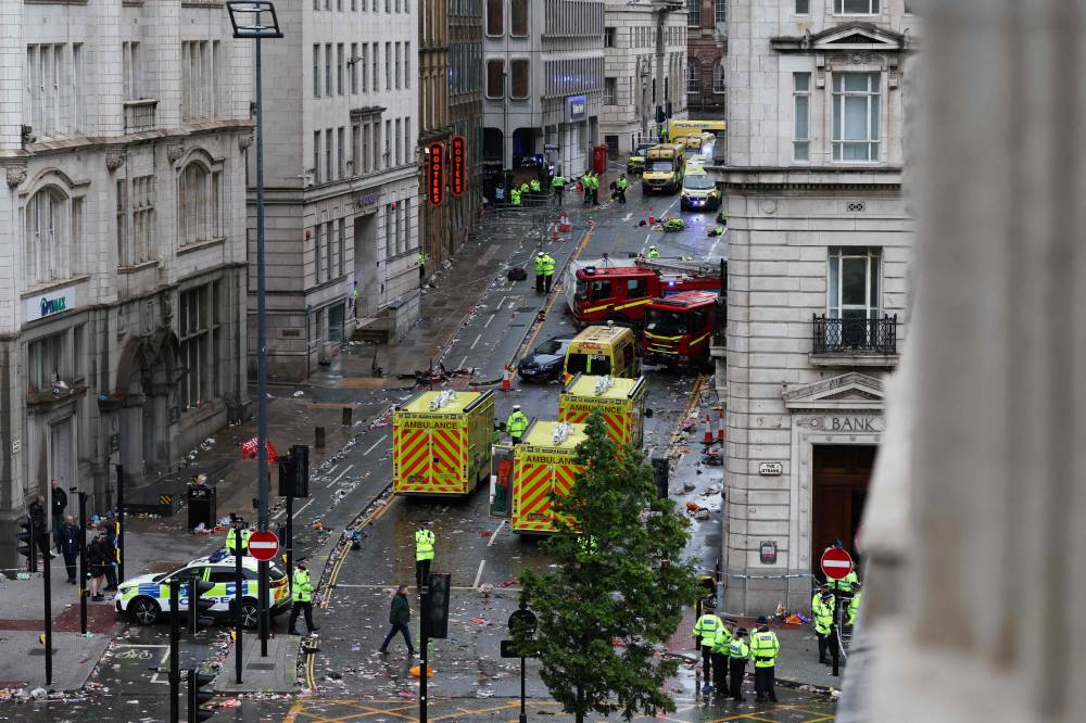Police officers investigate the scene of an incident in Water Street, on the sidelines of an open-top bus victory parade for Liverpool's Premier League title win, in Liverpool, north-west England on May 26, 2025. (Photo by Darren Staples / AFP)
