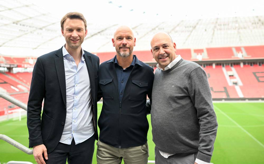 The new head coach of German Bundesliga team Bayer Leverkusen, Erik ten Hag (C), Simon Rolfes (L) and Fernando Carro (R) are seen after a press conference at the BayArena in Leverkusen, western Germany, on May 26, 2025. Hag will take over as head coach of German Bundesliga team Bayer Leverkusen, with a contract running until June 30, 2027, the club announced on May 26, 2025. (Photo by Ina FASSBENDER / AFP)