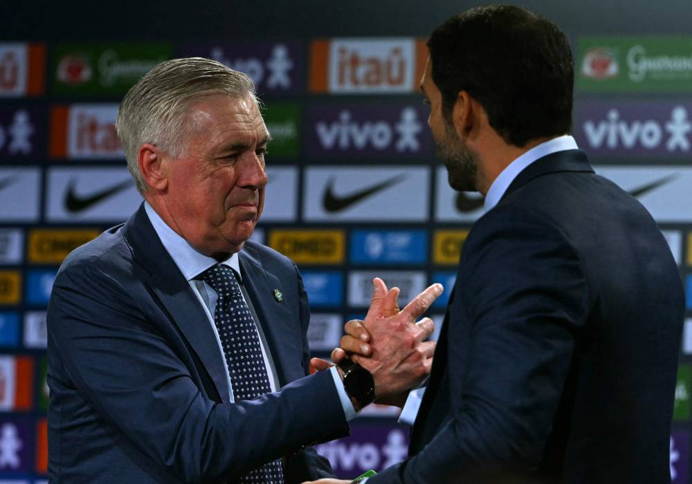 Brazil's football team new head coach, Italian Carlo Ancelotti (L) shakes hands with the president of the Brazilian Football Confederation (CBF) Samir Xaud during his official presentation at a hotel in Barra da Tijuca neighbourhood, Rio de Janeiro, Brazil, on May 26, 2025. (Photo by Mauro PIMENTEL / AFP)