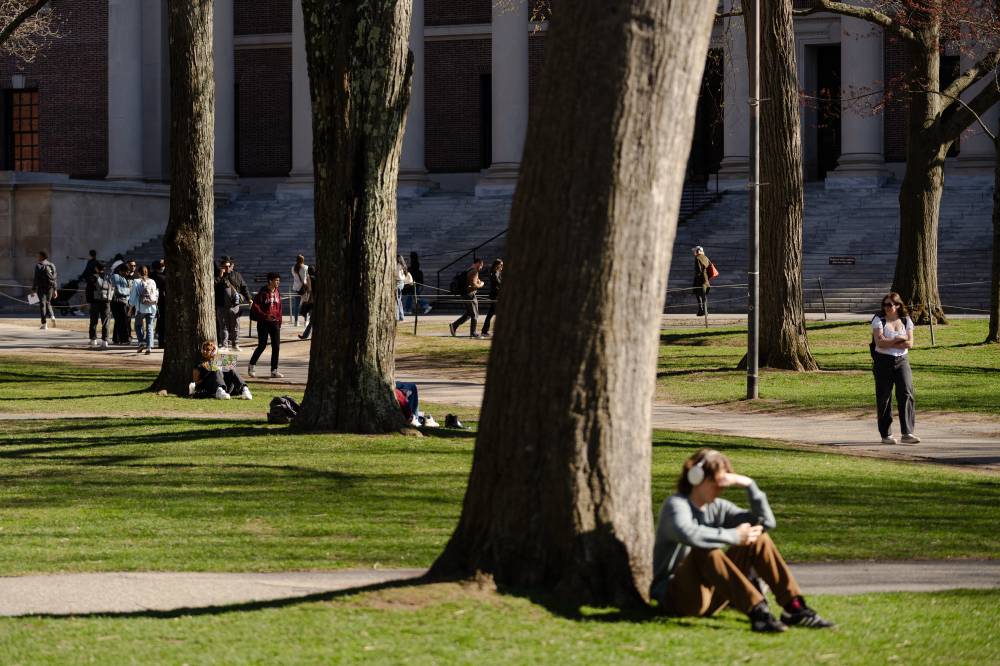 People sit on Harvard Yard at Harvard University on April 17, 2025 in Cambridge, Massachusetts. - (Photo by Sophie Park / AFP)