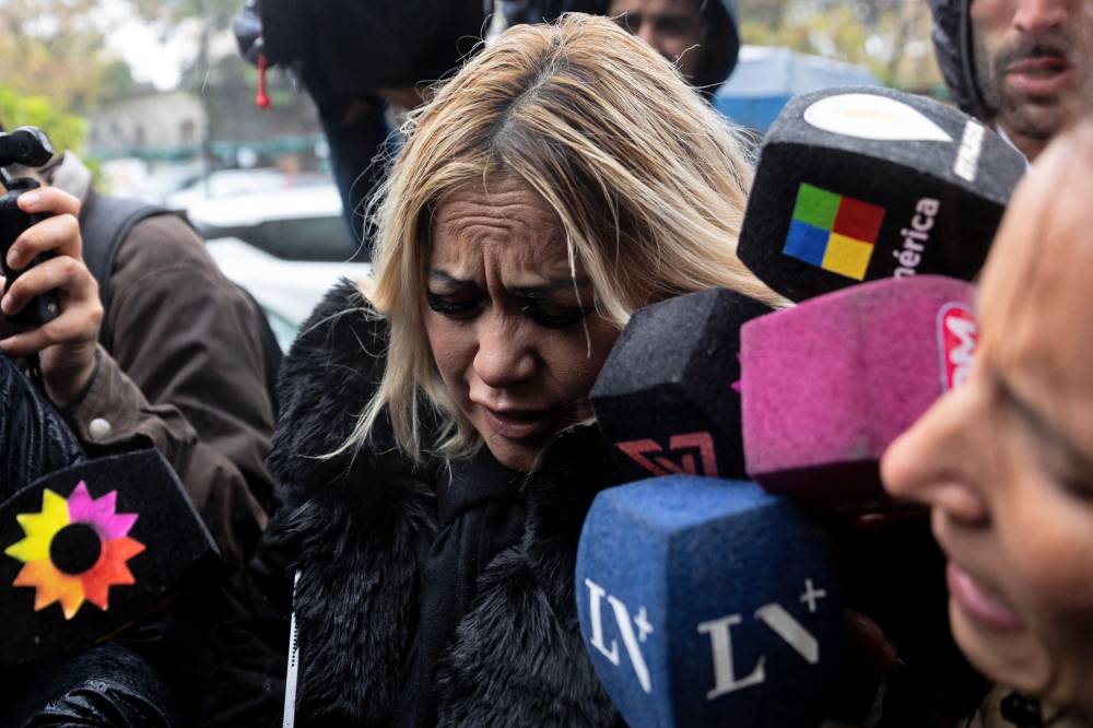Veronica Ojeda, former wife of Argentine football legend Diego Maradona, tries to make her way through the press on arrival in court for a trial hearing in San Isidro, outskirts of Buenos Aires on May 27, 2025. The trial, which hangs in the balance over questions about judge Julieta Makintach's impartiality, was suspended last week after defense lawyers said her involvement in a documentary related to the case constituted a possible breach of her duty, influence peddling and even bribery. The possibility of her removal risks nullifying the proceedings. (Photo by TOMAS CUESTA / AFP)