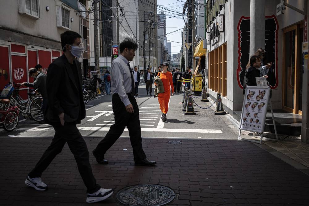 Pedestrians walk along a street in Osaka on April 14, 2025. -(Photo by PHILIP FONG / AFP)