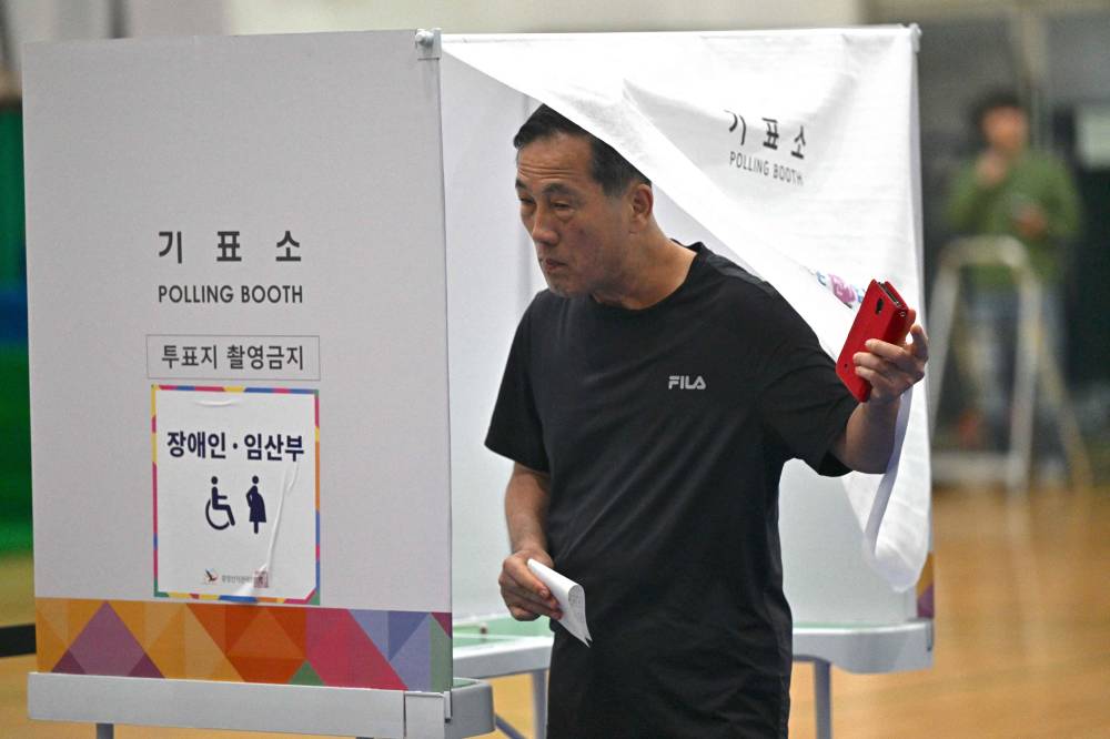 A man exits a polling booth as he votes during the presidential election in Seoul on June 3, 2025. Polls opened June 3rd for South Korea's snap presidential election, with the country voting to choose a new leader after ex-president Yoon Suk Yeol was impeached over his abortive declaration of martial law.

