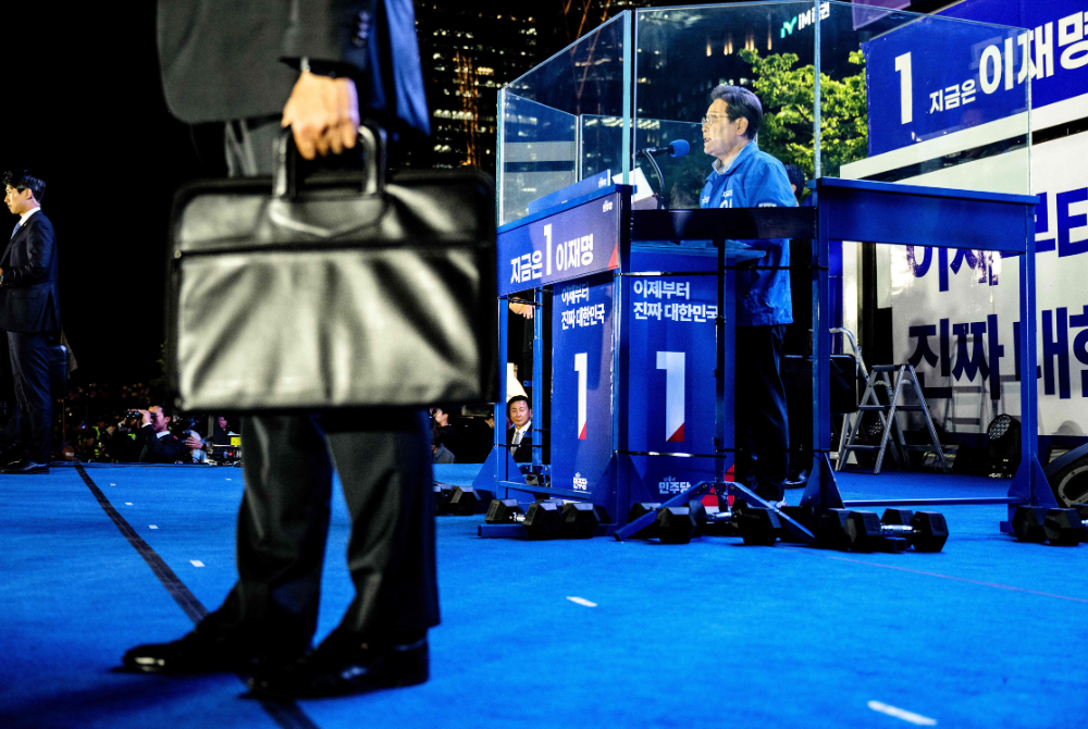 Lee Jae-myung (R), the presidential candidate for South Korea's Democratic Party, speaks onstage during his final election campaign event ahead of the upcoming June 3 presidential election in Seoul on June 2, 2025. (Photo by Anthony WALLACE / AFP)