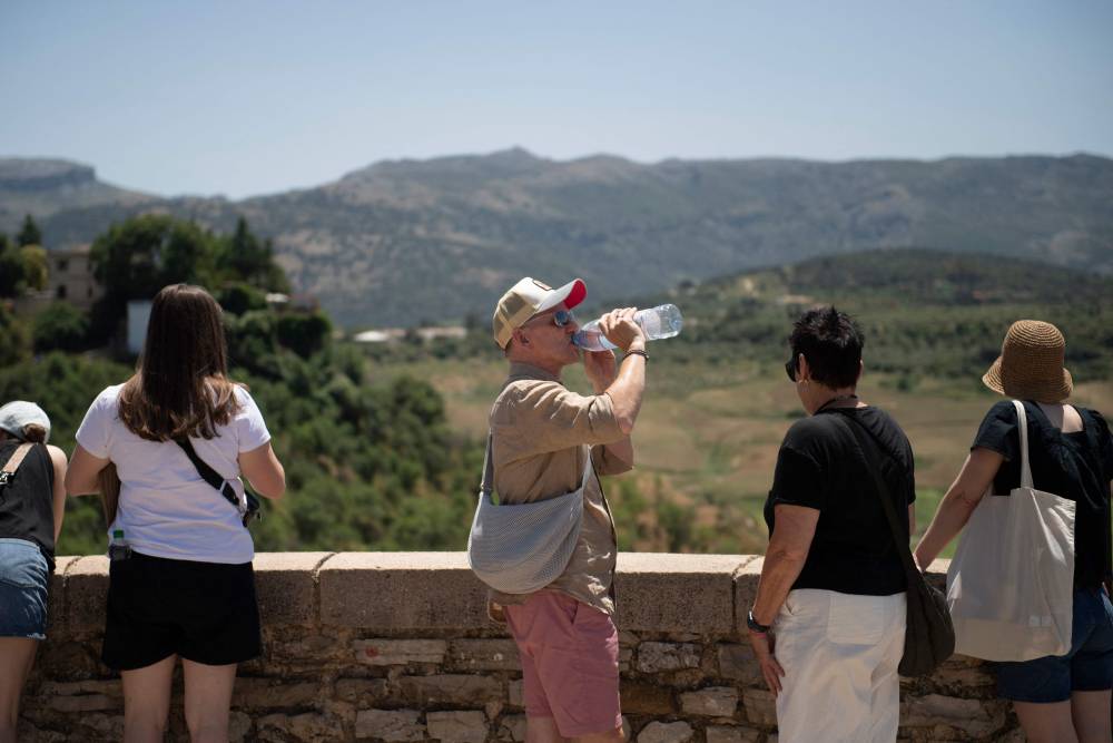 A man drinks water in Ronda, southern Spain as the country faces the first heatwave of the season, on May 28, 2025. (Photo by JORGE GUERRERO / AFP)