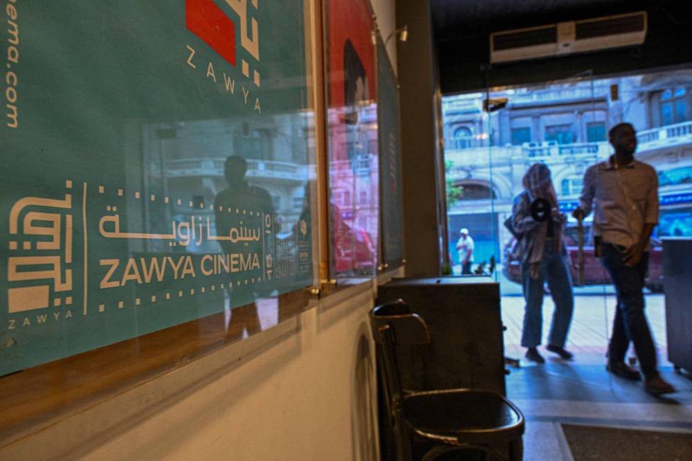 People arrive at the Zawya cinema in downtown Cairo on May 1, 2025. In the heart of Cairo, a small cinema has for over a decade offered a unique space for independent film in a country whose industry is largely dominated by commercial considerations (Photo by Khaled DESOUKI / AFP)