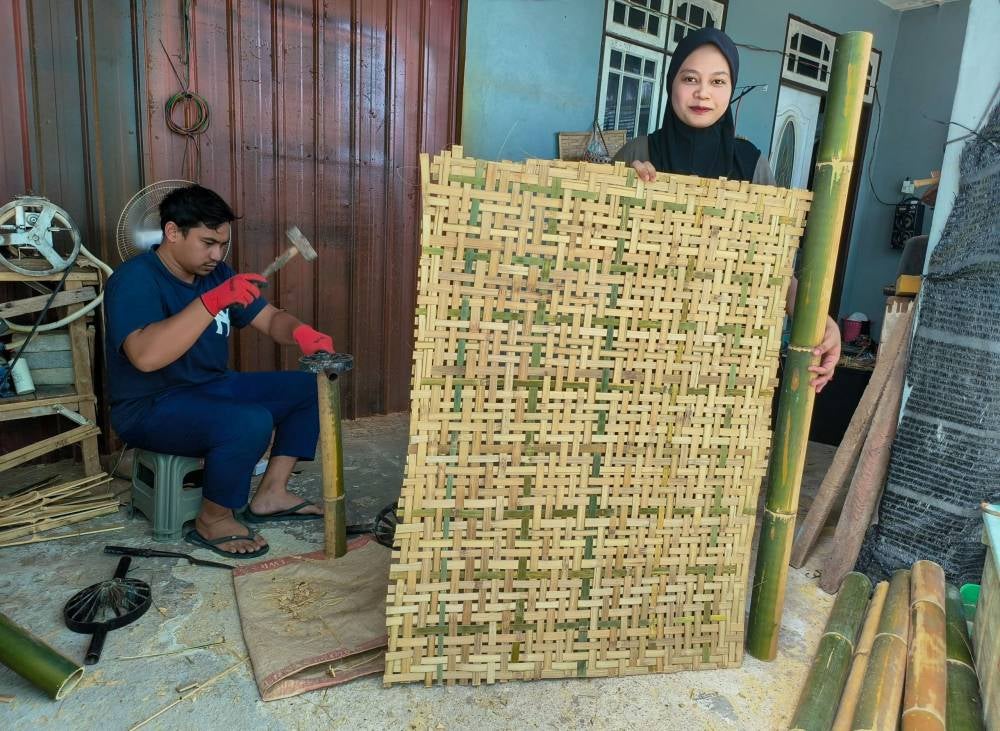 Diniey Iqbal Che Kar, 30 (left), and Nuur Faraiin Mat Rowi, 26 (right), showcasing their handmade weavings at Kampung Talak. - Bernama photo