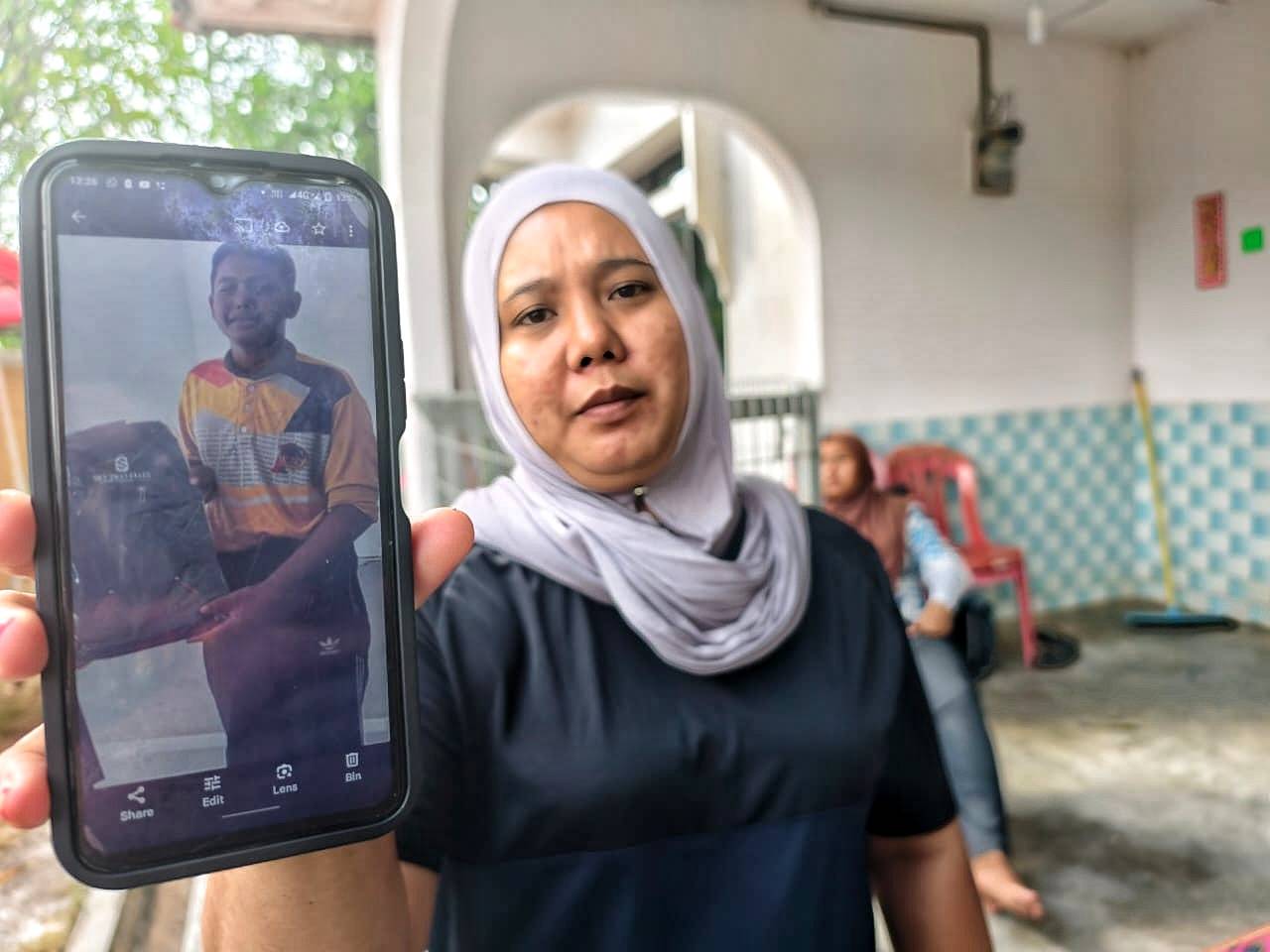 Norehan shows a photo of her second child, Muhamad Aidil Asyraf, who has yet to be found.