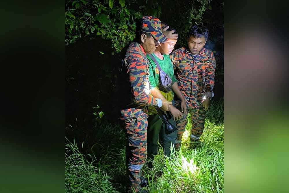 Muhamad Aidil Asyraf (centre), who appeared weak, being supported by firefighters after being found safe.