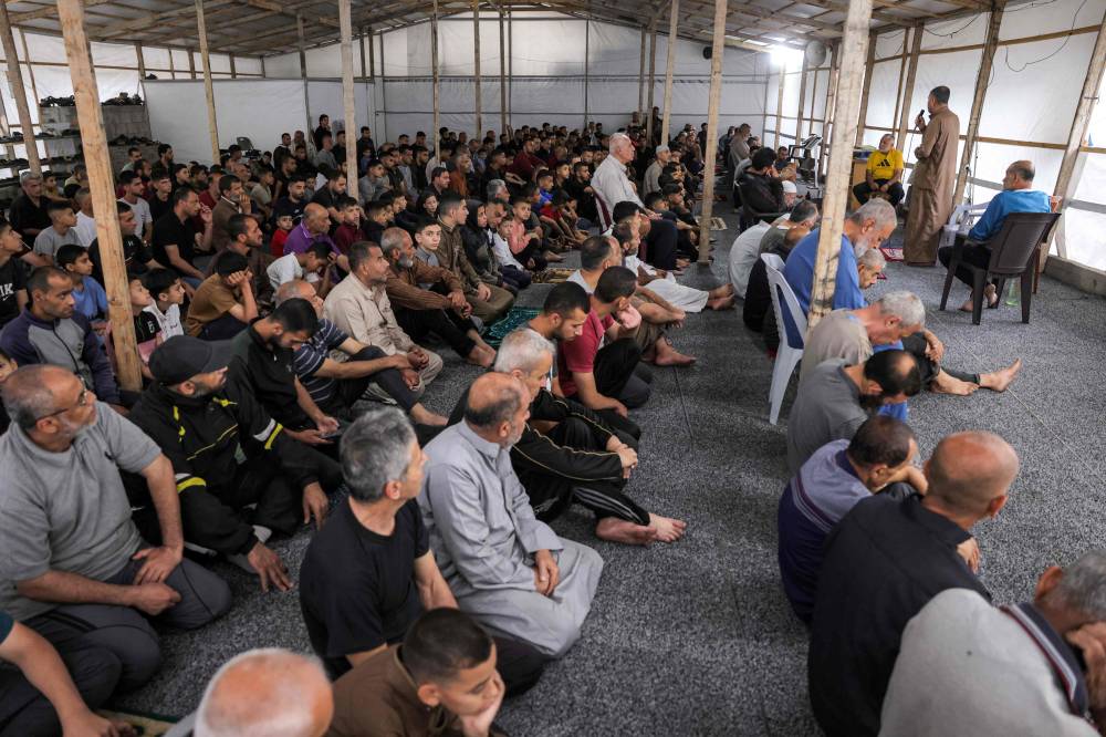 Muslim worshippers attend the sermon during the early morning prayers for Eid al-Adha, the feast of sacrifice, in the make-shift prayer room of the Nour mosque in the Abu Amin neighbourhood in northeastern Gaza City on June 6, 2025. - (Photo by BASHAR TALEB / AFP)