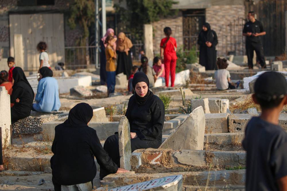 Palestinians visit the graves of their loved ones on the first day of the Muslim Eid al-Adha festival in Nuseirat, in the central Gaza Strip, on June 6, 2025. - (Photo by EYAD BABA / AFP)