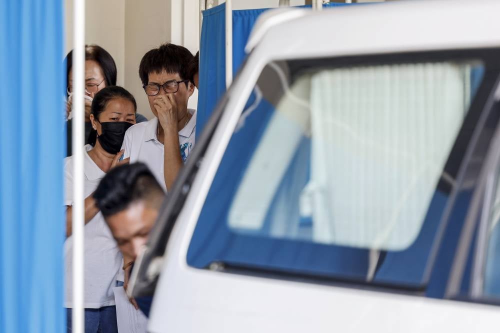 Several family members of the victims of the capsized boat in the waters off Tanjung Harapan, Port Klang, last Friday were overcome with grief as the bodies of the married couple, Gan Hon Tat, 32, and Careen Man, 29, were brought out of the Forensic Unit at Shah Alam Hospital on June 8. Photo by Bernama