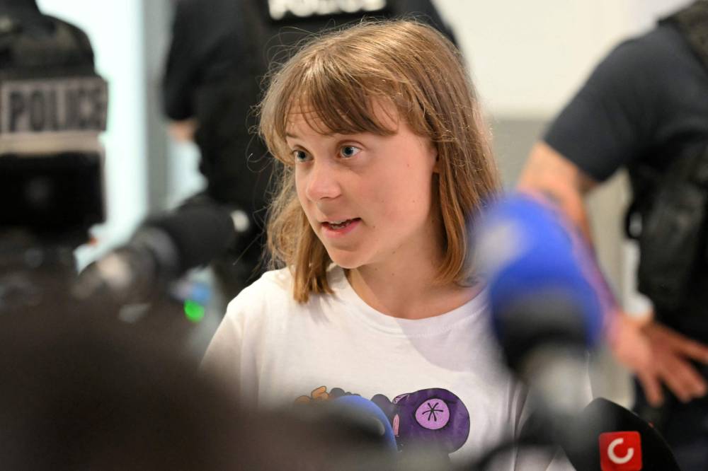 Swedish campaigner Greta Thunberg talks to journalists upon her arrival to Roissy-Charles de Gaulle Airport, as she left Israel on a flight to Sweden via France, after she was detained along with other activists aboard a Gaza-bound aid boat, on June 10, 2025. Thunberg departed Israel on a flight from Tel Aviv to Sweden (via France). - (Photo by HUGO MATHY / AFP)