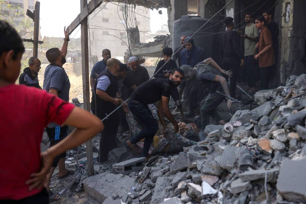 Palestinians prepare to carry an injured person, pulled from the rubble of a home that was targeted in an Israeli strike in the Saftawi neighbourhood, west of Jabalia, in the northern Gaza Strip on June 9, 2025. Photo by Bashar Taleb/AFP