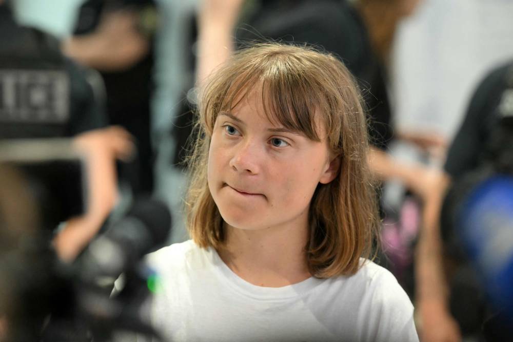 Swedish campaigner Greta Thunberg talks to journalists upon her arrival to Roissy-Charles de Gaulle Airport, as she left Israel on a flight to Sweden via France, after she was detained along with other activists aboard a Gaza-bound aid boat, on June 10, 2025. - (Photo by HUGO MATHY / AFP)