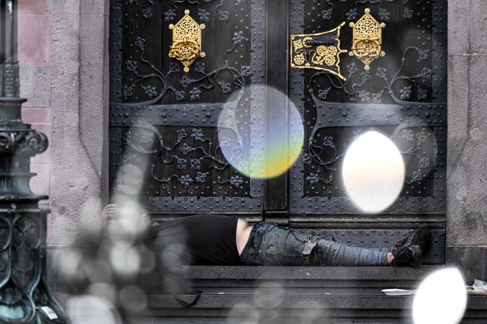 A man rests near a fountain on the central Roemer Square in the city of Frankfurt am Main, western Germany, on June 10, 2025. (Photo by Kirill KUDRYAVTSEV / AFP)