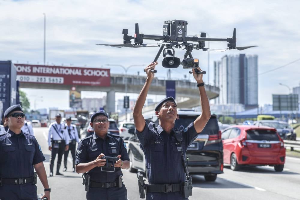 Police today deployed drones to go after motorcyclists not using their designated lane on the Federal Highway. Photo by Bernama