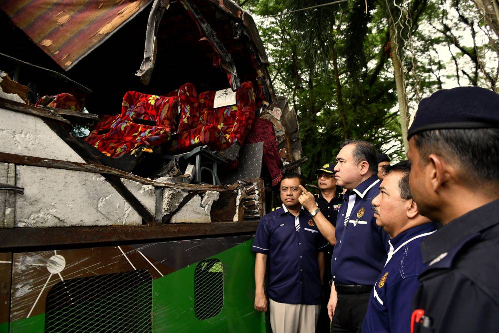 Transport Minister Anthony Loke examines the condition of the bus involved in the accident involving Universiti Pendidikan Sultan Idris (UPSI) students at the Gerik District Police Headquarters (IPD) compound today. - Photo by Bernama
