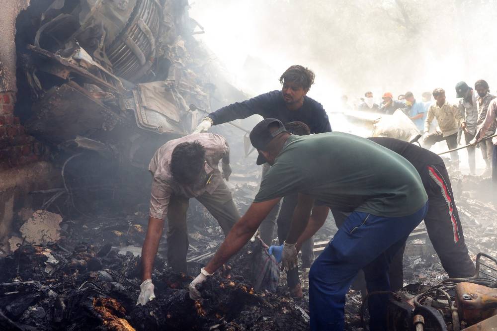 Rescue officials work at the site where Air India flight 171 crashed in a residential area near the airport in Ahmedabad on June 12, 2025. - (Photo by SAM PANTHAKY / AFP)
