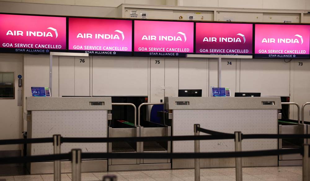 A photograph taken on June 12, 2025 shows the closed check-in desks of Air India warning of the cancellation of the service to Goa, at the south terminal of Gatwick Airport, south of London (Photo by HENRY NICHOLLS / AFP)