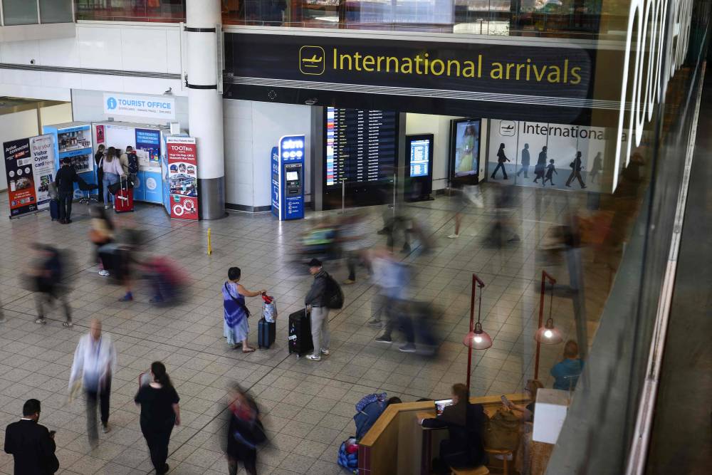 Passengers arrive at Gatwick Airport, south of London (Photo by HENRY NICHOLLS / AFP)