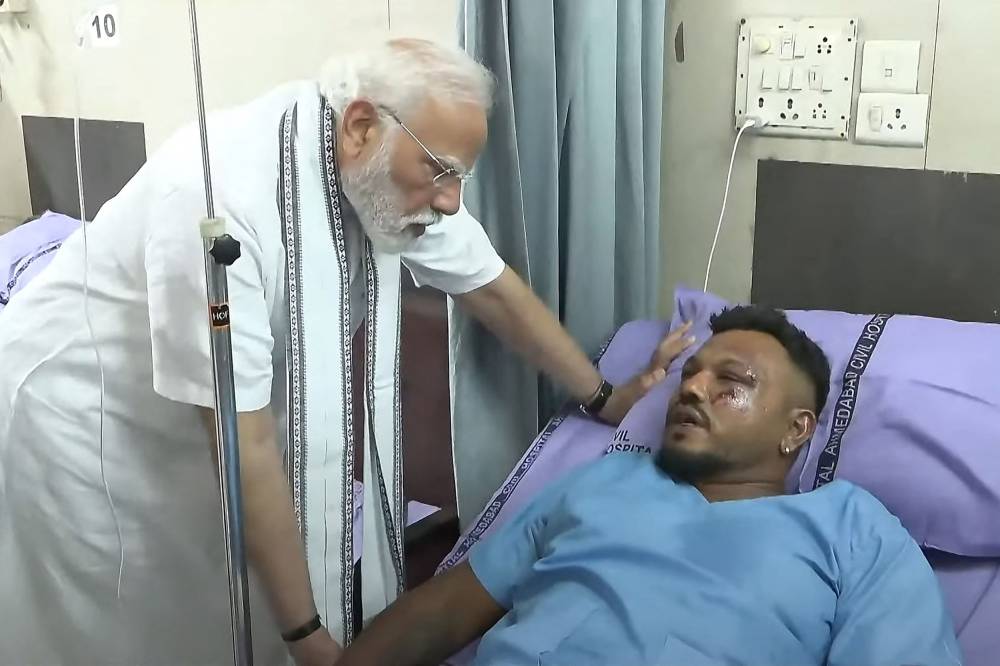 This screengrab of video footage taken and released by the Narendra Modi Youtube Channel on June 13, 2025 shows India's Prime Minister Narendra Modi (L) meeting with Vishwash Kumar Ramesh, sole survivor of the Air India flight 171 crash, at a hospital in Ahmedabad. - (Photo by NARENDRA MODI YOUTUBE CHANNEL / AFP)