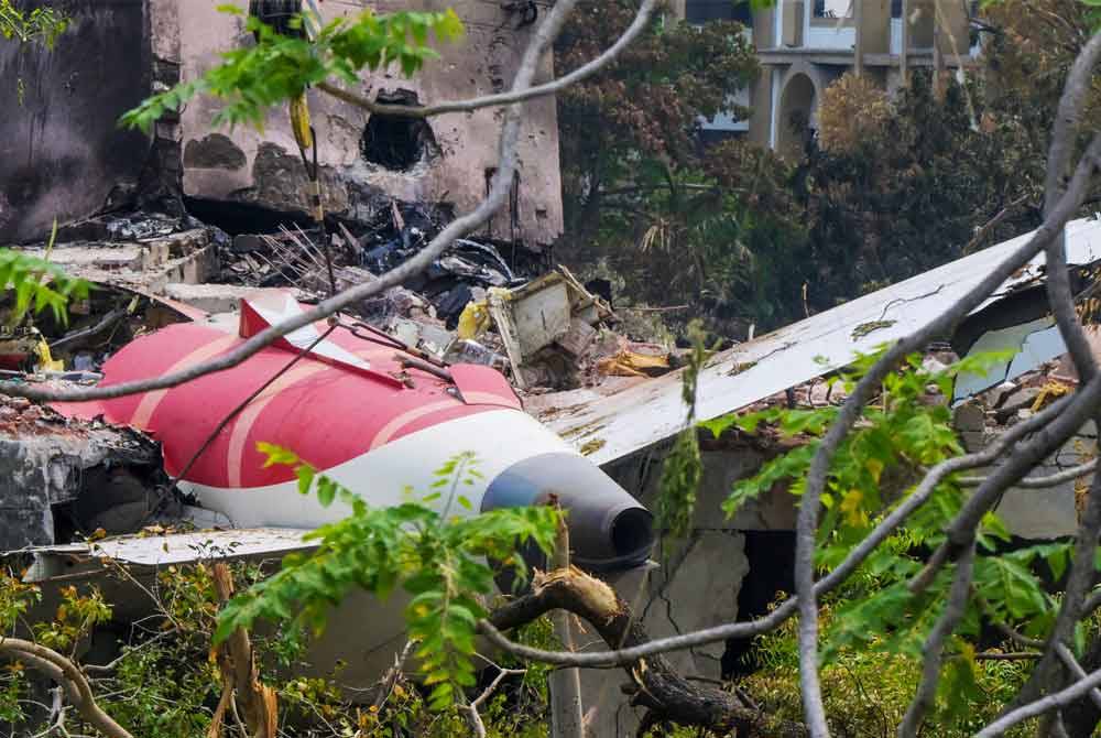 A crane lifts the tail section of the aircraft from the crash site, recorded in a residential area near the airport in Ahmedabad on June 14, 2025. - Photo by AFP