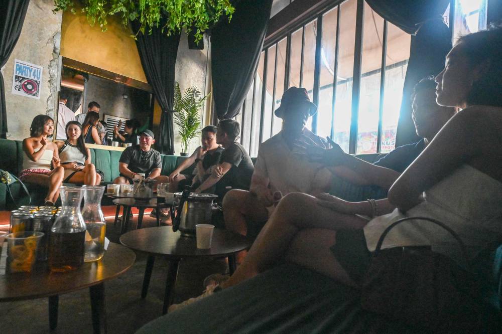 This photo taken on May 24, 2025 shows people mingling over coffee drinks at an alcohol-free clubbing event in Singapore. Swaying to dance music and TikTok-fuelled pop under a disco ball, young punters are packed shoulder to shoulder while sipping on coffee, their energy powered by pour-overs rather than pints. (Photo by Roslan RAHMAN / AFP)