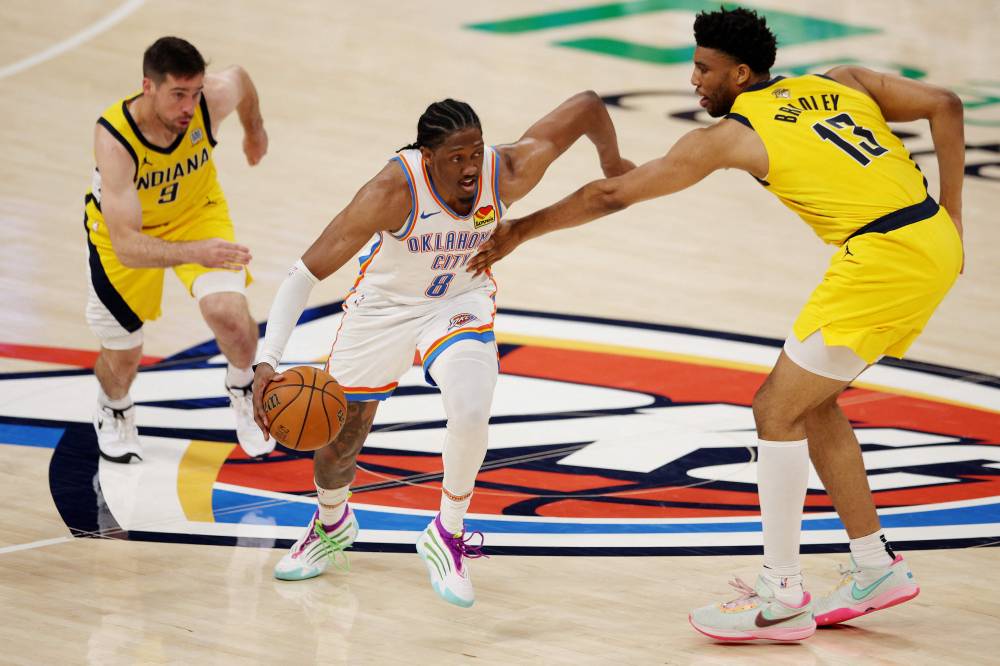 Jalen Williams #8 of the Oklahoma City Thunder is defended by Tony Bradley #13 and T.J. McConnell #9 of the Indiana Pacers during the third quarter in Game Five of the 2025 NBA Finals at Paycom Centre. Photo by William Purnell/AFP