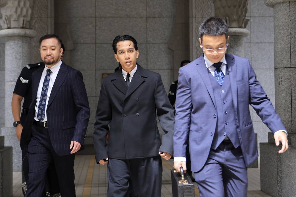 Singer Naim Daniel (C) pleaded not guilty at the Sessions Court in Putrajaya today to a charge of committing sexual assault against a 17-year-old girl at a hotel in May. - Photo by Bernama