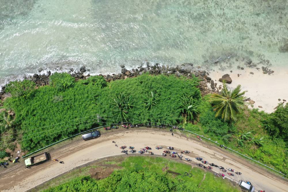 This aerial picture shows motorists waiting in a queue to pass through a section of road affected by a landslide caused by a 6.2 magnitude earthquake in Majene, West Sulawesi on Jan 19, 2021. - (Photo by ADEK BERRY / AFP)