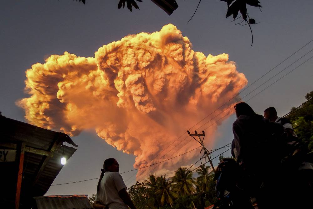 Villagers watch the eruption of Mount Lewotobi Laki-Laki as seen from Talibura village in Sikka, East Nusa Tenggara, on June 17, 2025. A volcano in eastern Indonesia spewed a colossal ash tower into the sky on June 17, authorities said, after they raised its alert level to the highest of a four-tiered system. (Photo by AFP)